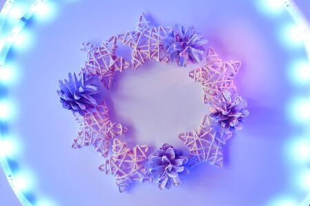 Christmas frame with stars and cones with lights on white background, the New year concept. toned in neon colorsの写真素材