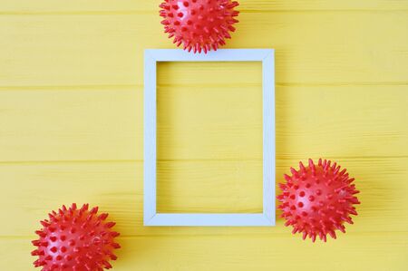 Abstract red balls virus strain model with wooden frame on yellow background. Respiratory syndrome coronavirus and Novel coronavirus covid-19 with place for text background. Virus Pandemic Protection Conceptの写真素材