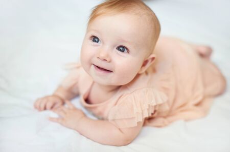 Portrait of a sweet infant smile wearing a pink dress in studioの写真素材