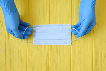 close up of doctor hand gloves with a medical face mask for protection against infection. Stop...