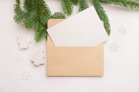 Christmas greeting card with envelope on wooden white background with fir tree branches and happy...