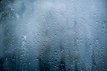 Rainy background, rain water drops on the window or in shower stall, autumn season backdrop, abstract textured wallpaperの写真素材