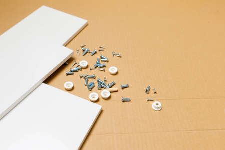 mechanic assembled the furniture in the house according to the manual, along with the mechanic equipment. Nails screws and white boards for the cabinet with place for your textの写真素材