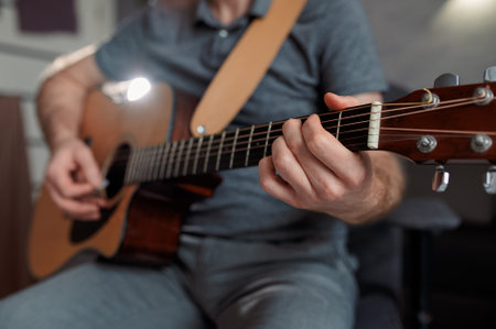 Man paying a acoustic guitar in sound studio. Male musician playing music instrument