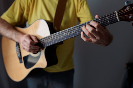 Guitarist on acoustic guitar playing melody. Close up musician instrument with pick in handの写真素材