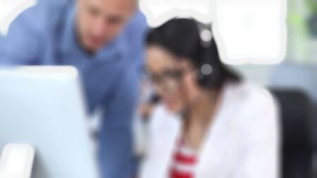 Cheerful business people in a meeting at office with blurry view.の写真素材