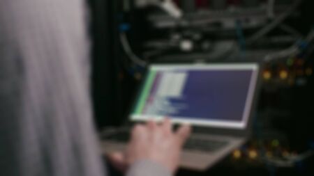 Blurry view of professional development programmer working in programming website a software and...