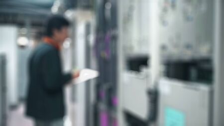 Blurred Young man diagnoses problems in the work of the information center. System administrator...