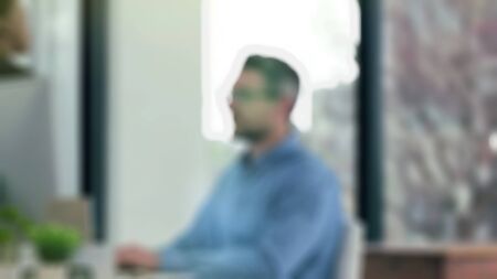 Young attractive businessman happy and successful at work at computer desk satisfied and smiling relaxed leaning on chair in front of office window  with blurry view.の写真素材
