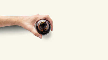 Man hand holding a bottle of beer top up view in a light white background with copy spaceの写真素材