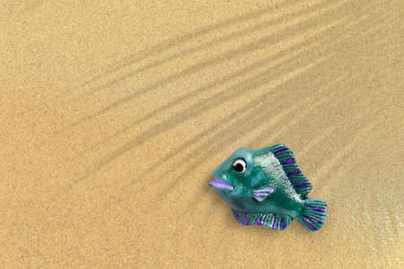 Top up view of green rubber fish on sand beach. vacation concept background.の写真素材