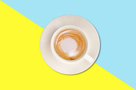 Hot cappuccino with simple foam on white cup isolated on colored background.