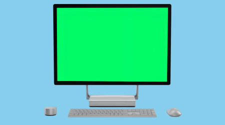 A computer setup featuring a monitor, keyboard, and mouse with a green screen.の写真素材