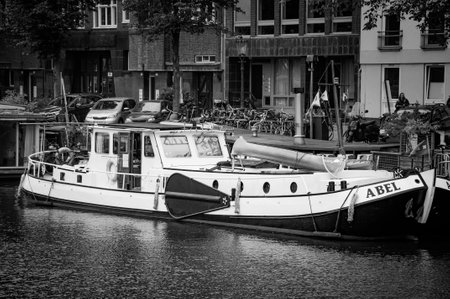 AMSTERDAM, NETHERLANDS. JUNE 06, 2021. Beautiful view of Amsterdam with typical dutch houses, bridges and chanel. Small boats on the embankment. Black and white photography.のeditorial素材