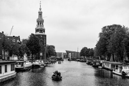 AMSTERDAM, NETHERLANDS. JUNE 06, 2021. Beautiful view of Amsterdam with typical dutch houses, bridges and chanel. Small boats on the embankment. Black and white photography.のeditorial素材