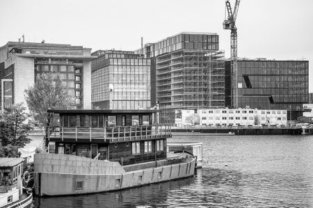 AMSTERDAM, NETHERLANDS. JUNE 06, 2021. Beautiful view to a shipping channel and bridges. Black and white photography. Small boats, ships and barges in the port. Black and white photography.のeditorial素材