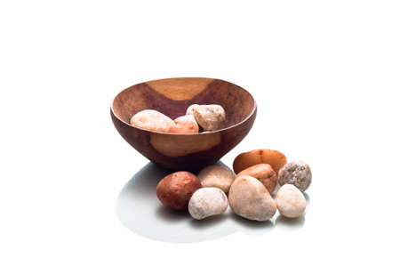 Small wooden bowl containing stones isolated on a white backgroundの写真素材