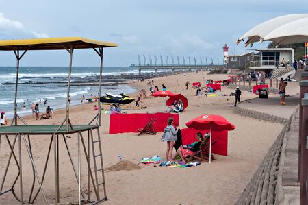 DURBAN, SOUTH AFRICA - JULY 09, 2016: Locals and tourists on the beach near the Millennium Pier and lighthouse in Umhlanga Rocksのeditorial素材