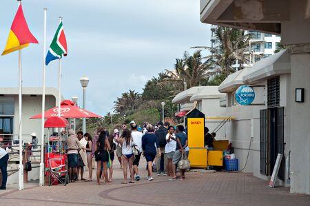 DURBAN, SOUTH AFRICA - JULY 09, 2016: Locals and tourists on the promenade near the Millennium Pier and lighthouse at Umhlanga Rocks beachのeditorial素材