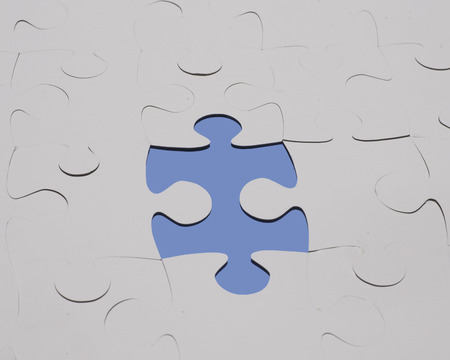 Jigsaw cardboard shapes in gray with a color part.