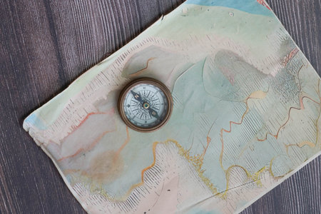 Vintage brass compass on a hand made old fashioned map for exploration