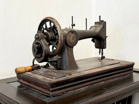 Classic antique colonial tailor sewing machine, unused and displayed on dark wooden antique table....