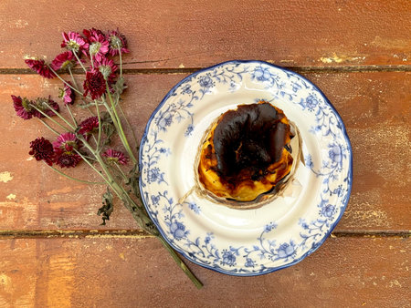 Various baked cheese egg tart, egg tart pastry served on white chinoiserie saucer plate, with daisy...