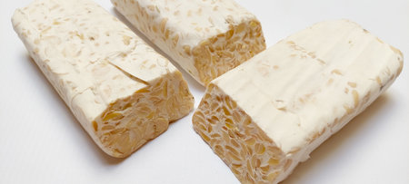 Close up sliced photo of Tempe or Tempeh, showing the Rhizopus Oligosporus, a fungi species that's used in fermentation of soybeans to bind and make the edible Tempeの写真素材