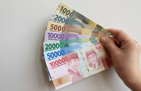 Portrait of Indonesian Rupiah (IDR) banknotes, often abbreviated as 'Rp', isolated on a white wall background.の写真素材
