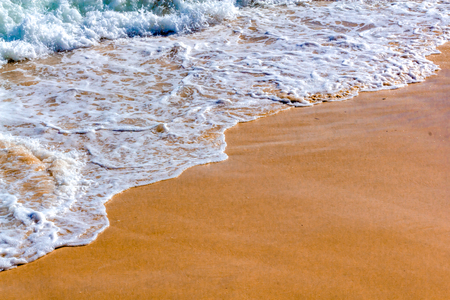 Close up photo of calm waves from an ocean in a beach in summer.の写真素材