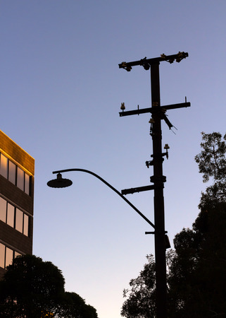 Silhouette of street lamp and electrical tower in the morningの写真素材