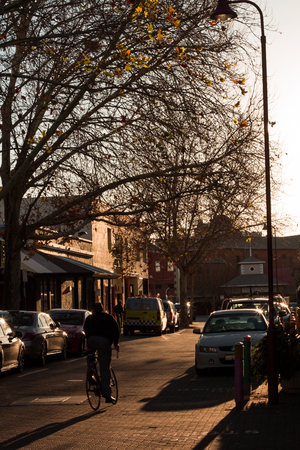 A cyclist cycling down a road in Fremantle, Perth, Australia in sunset.の写真素材