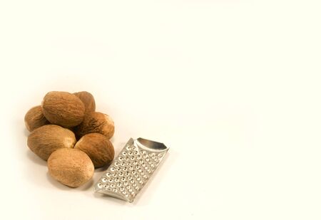 Nutmeg and grater isolated on whiteの写真素材