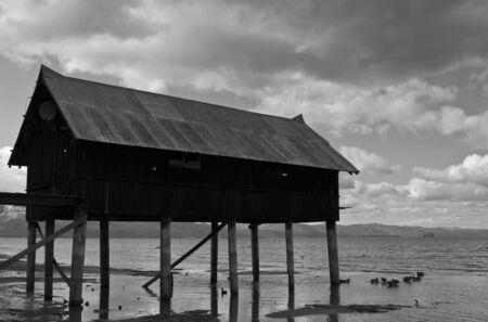 Profile of shack on dock with cloudscape in backgroundの写真素材