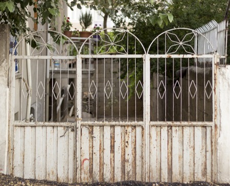 Old white gate leading to a village gardenの写真素材