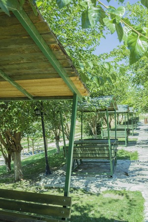 Series of green bench huts in a sunny outdoors parkの写真素材