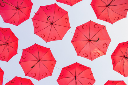 Red Turkish umbrellas strung above a streetの写真素材