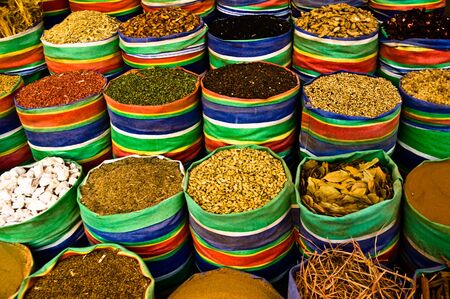 Spices for sale in large colourful open sacks at market.