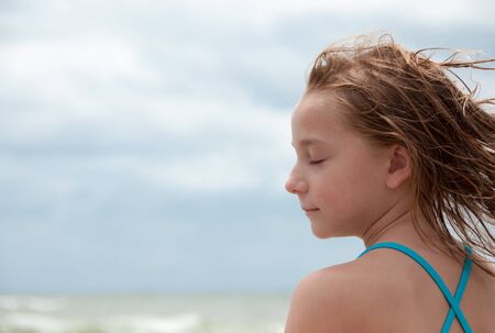 Girl with closed eyes relaxed at the beach.の写真素材