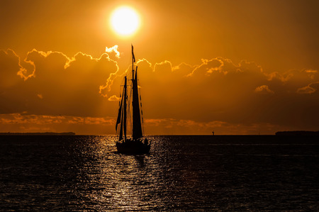 Yacht in the quiet sea during golden sunsetの写真素材