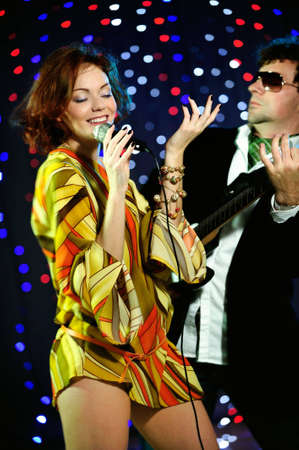 Female singer and male guitar player on stage