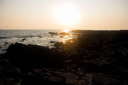 Waves break on the rocky beaches of Arambol in India.の写真素材