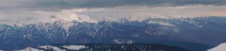 Panoramic view of the Caucasus mountains in the cloudy winter weatherの写真素材