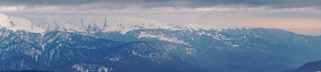 Panoramic view of the Caucasus mountains in the cloudy winter weatherの写真素材