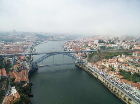 Panoramic view of the old city of Porto. One flew over the roofs of the houses, a river and a bridge.の写真素材