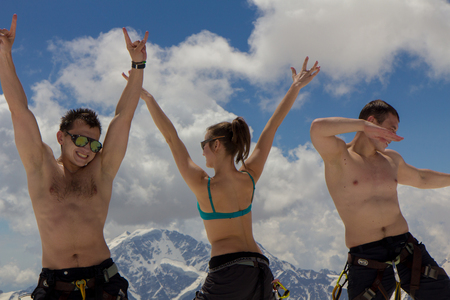 2014 07 Mount Elbrus, Russia: Men and a girl dance in front of the camera on the background of the mountains on the slope of Elbrusのeditorial素材