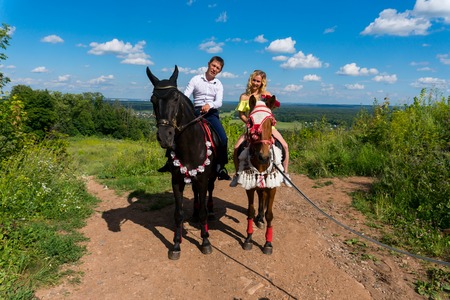 Young couple in love riding a horseの写真素材