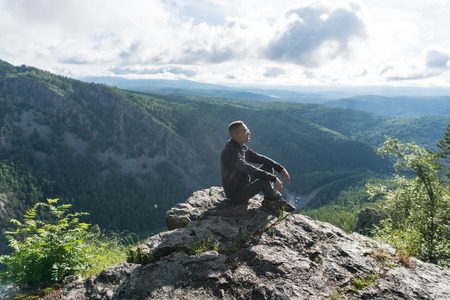 Man seat in a peak in Ural mountainsの写真素材