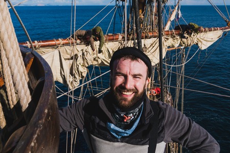 sailors work with sails at a height on a traditional sailboat in the seaの写真素材