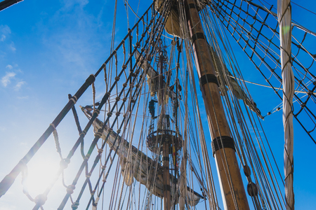 sailors work with sails at a height on a traditional sailboat in the sea